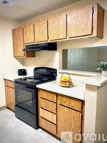 A kitchen with wooden cabinets and a black stove top.