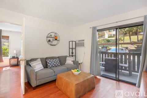 A living room with a grey couch and a brown coffee table.