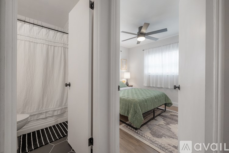 A bedroom with a bed and a ceiling fan.
