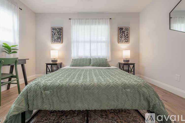 A bedroom with a large bed and two lamps on side tables.