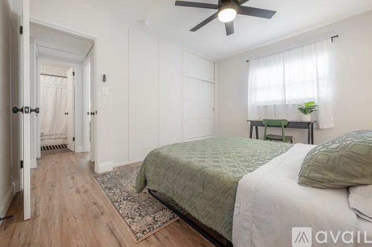A bedroom with a bed, a ceiling fan, and a rug.