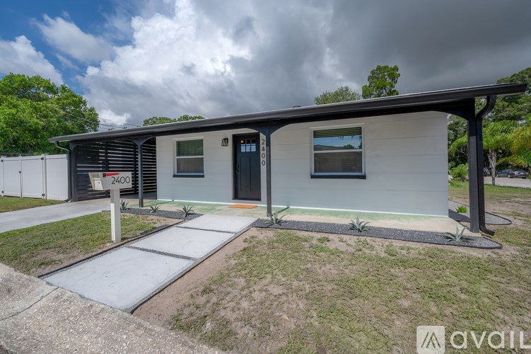 A modern house with a grey roof and a black door is for sale.