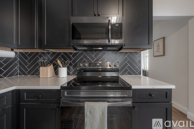 A modern kitchen with a stove top oven and microwave above it.