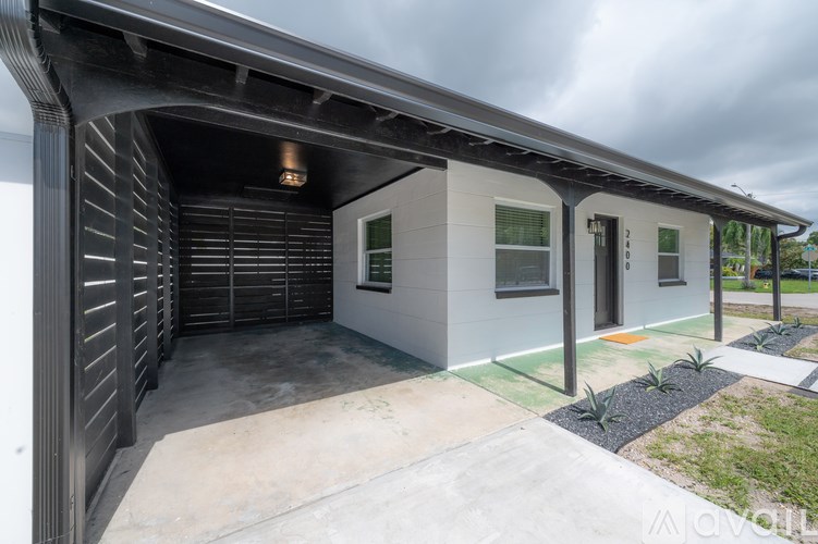 A modern house with a grey roof and a concrete driveway.