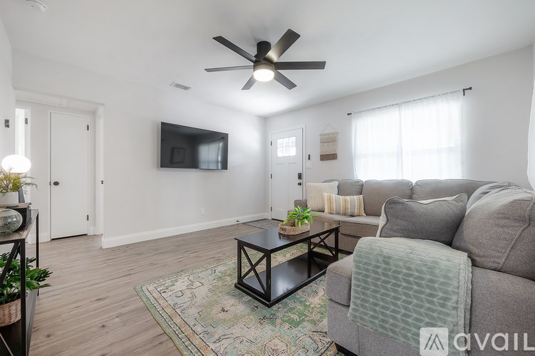 A living room with a grey couch and a black coffee table.