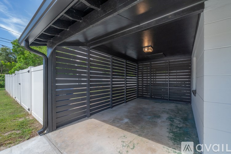 A garage with a black roof and a white wall.