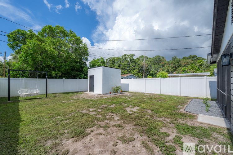 A backyard with a white fence and a small white shed.