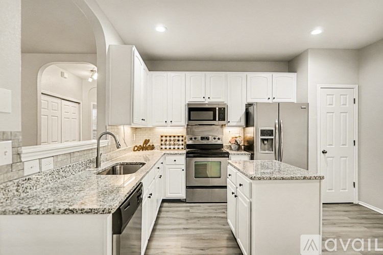 A modern kitchen with granite countertops and stainless steel appliances.