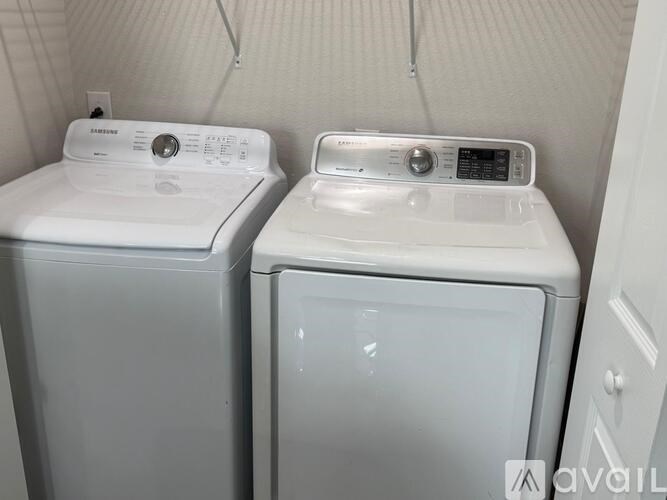 A white washing machine and dryer in a small room.