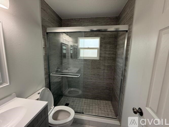 A bathroom with a toilet, sink, and walk-in shower.