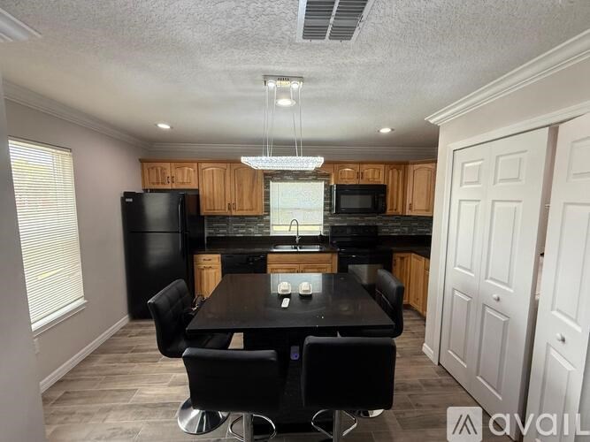 A kitchen with a black table and chairs.