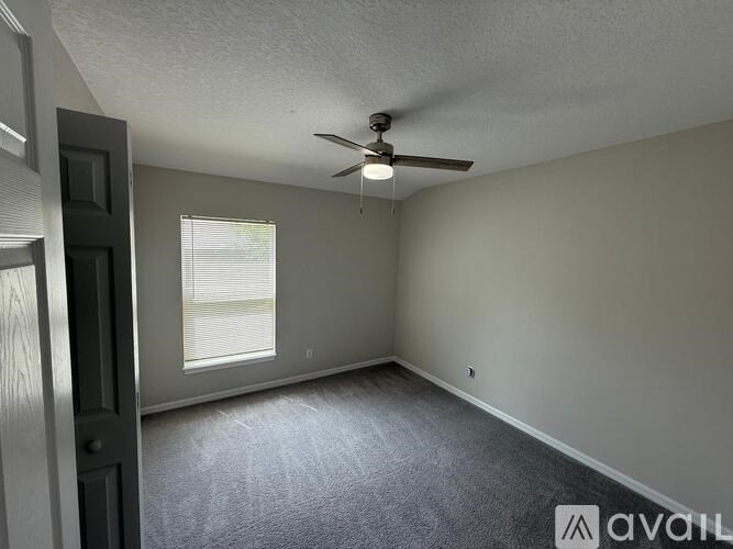 A room with a ceiling fan and a window.