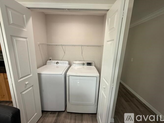 A laundry room with two washing machines and a dryer.