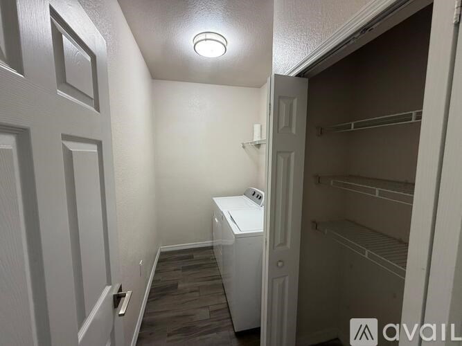A small white fridge in a narrow hallway.