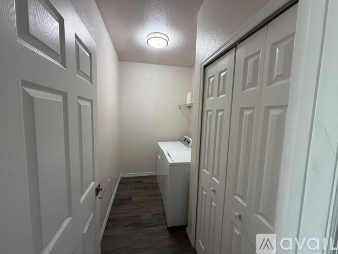 A small, white cabinet sits in the corner of a narrow hallway.