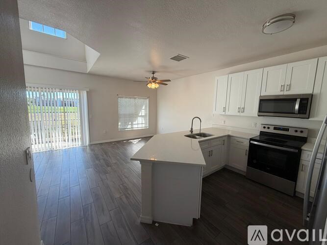 A kitchen with white cabinets and a wooden island.