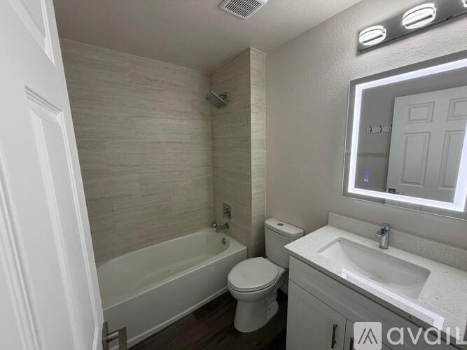 A bathroom with a toilet, sink, and bathtub.