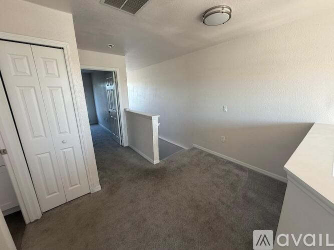A room with a white door and a carpeted floor.
