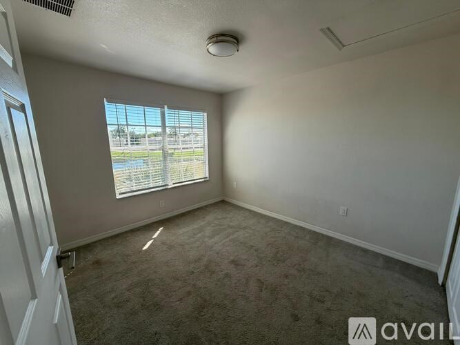 A room with a window overlooking a parking lot.