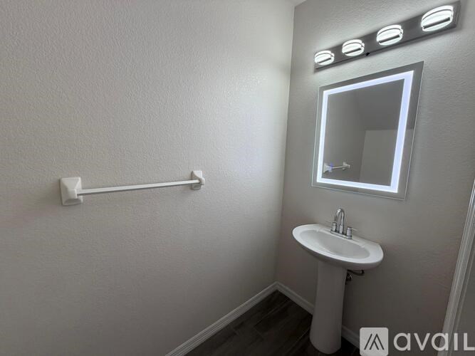 A bathroom with a sink, mirror, and lights.