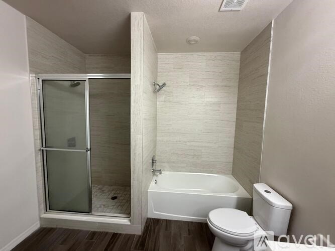 A small bathroom with a toilet, tub, and shower.