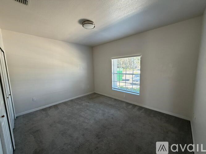 A room with a window and a poster on the wall.