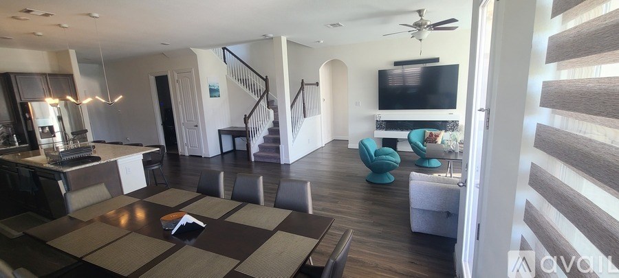 A living room with a brown rug and a television.