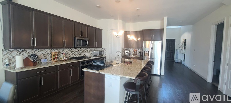 A kitchen with dark brown cabinets and a white countertop.