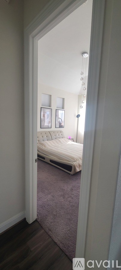 A bedroom with a bed and a chandelier.