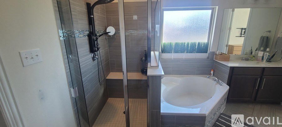 A bathroom with a glass shower stall and a white sink.