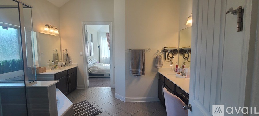A bathroom with a large mirror and a white chair.