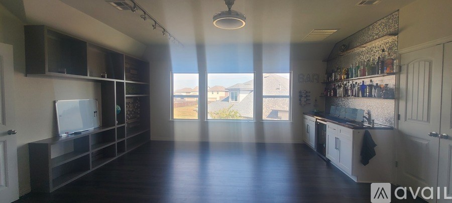 A large empty room with a flat screen TV mounted on the wall.