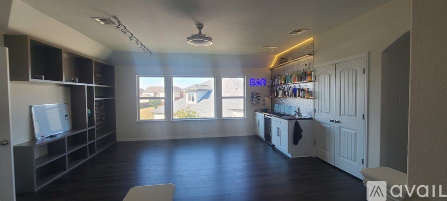 A spacious room with a bar area and a television.