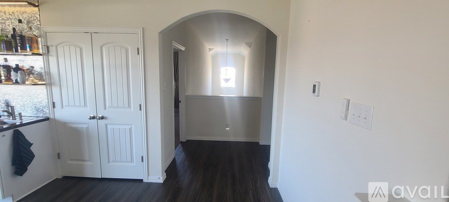 A kitchen with white cabinets and a black countertop.