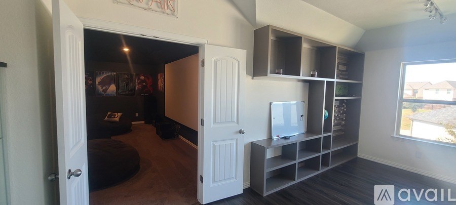 A room with a television and a large window.