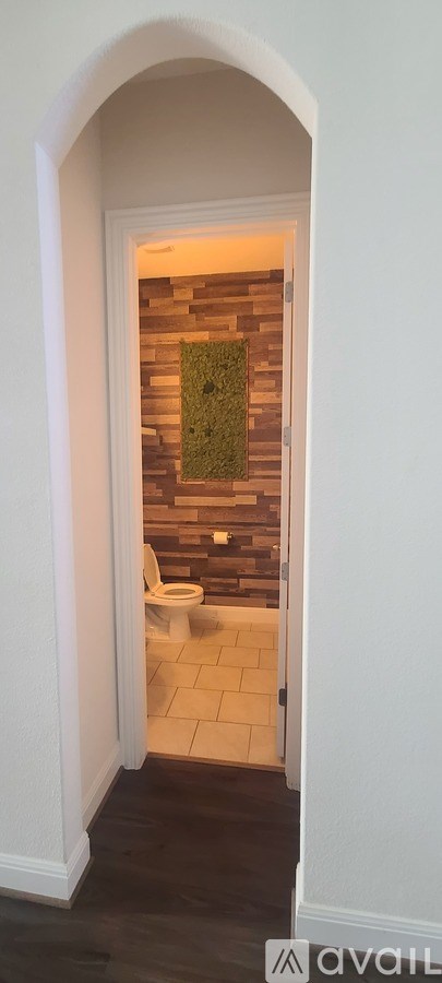 A bathroom with a toilet and a tiled wall.
