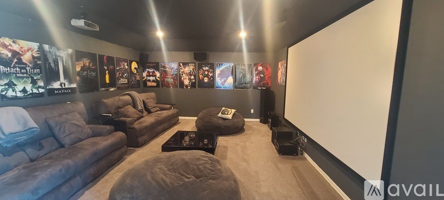 A home theater room with a large screen and comfortable seating.