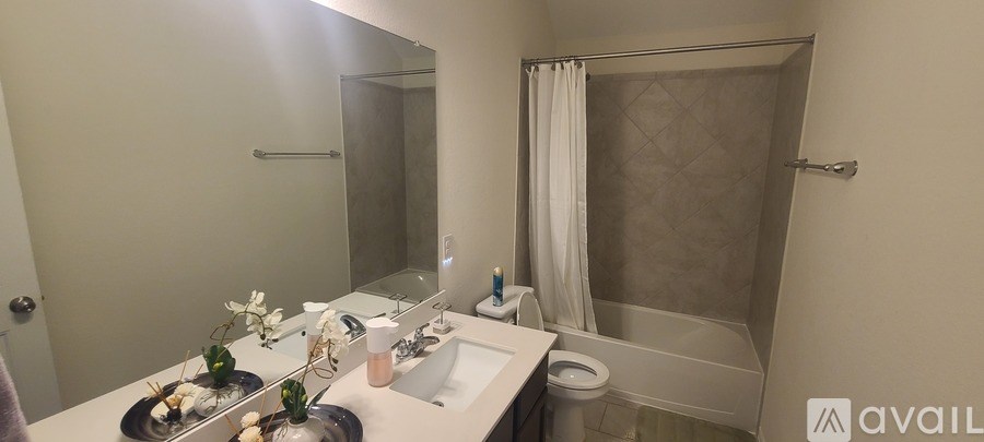A bathroom with a sink, mirror, toilet and bathtub.