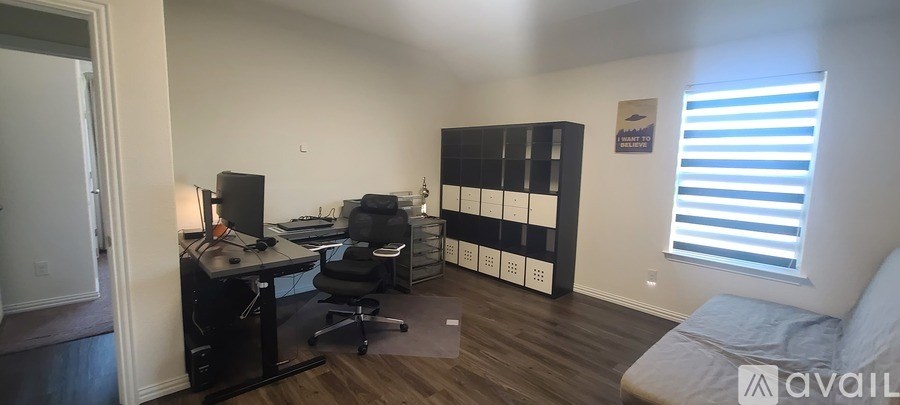 A room with a desk, chairs, and a bed.