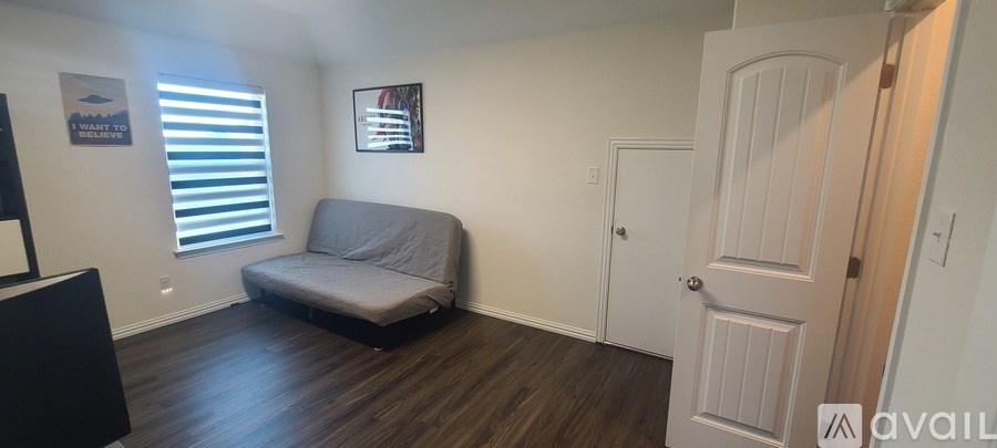 A living room with a grey couch and a white door.