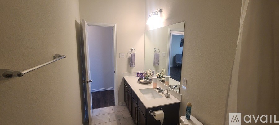 A bathroom with a sink, mirror, and toiletries.