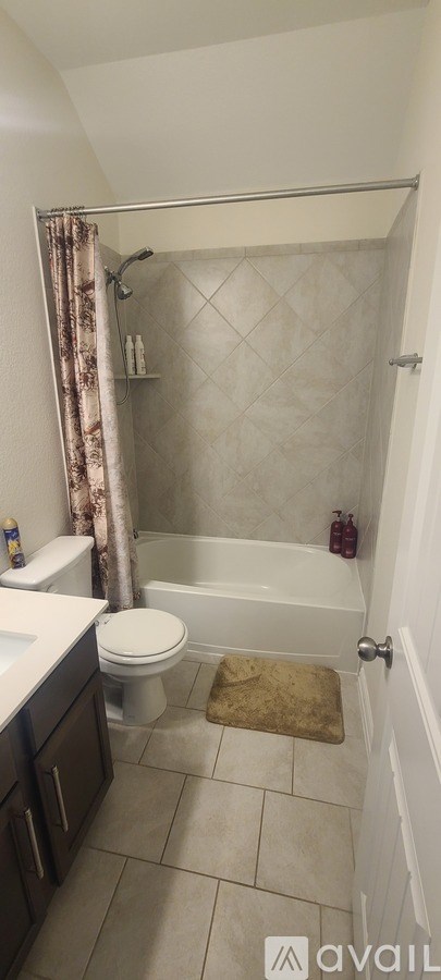 A bathroom with a toilet, sink, and shower.