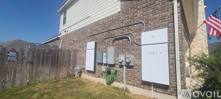 A Tesla Powerwall installation on the side of a house.