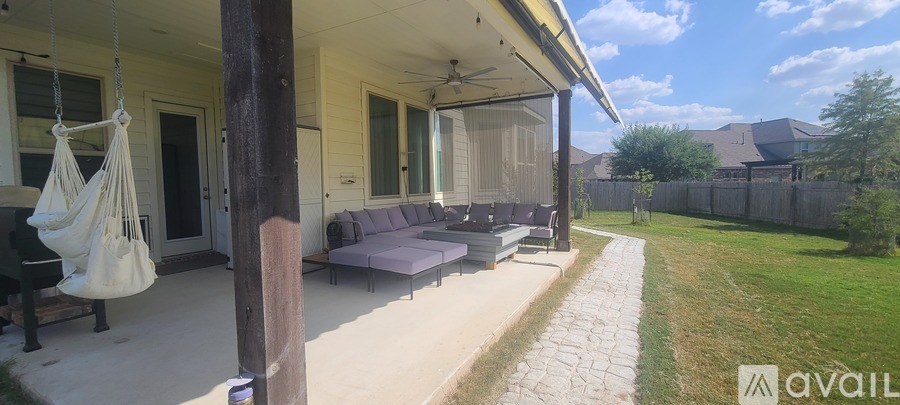 A porch with a hanging chair and a couch.