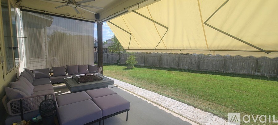 A patio with a couch and a table under a yellow canopy.