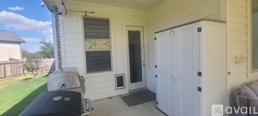 A white wooden shed is attached to a house.
