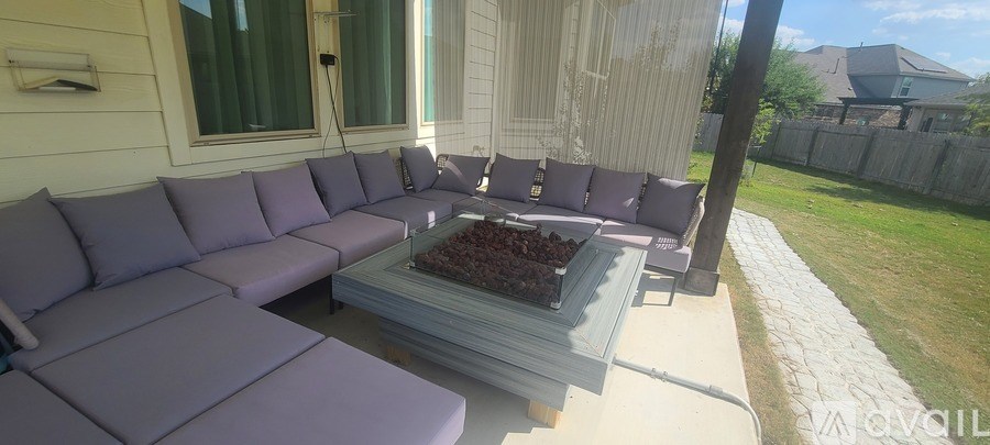 A patio with a purple couch and a coffee table.