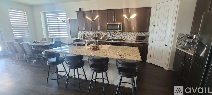 A kitchen with a bar area and a countertop with a marble top.