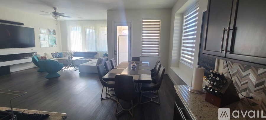 A modern living room with a large TV and a dining area.