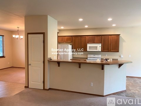 A kitchen area with a counter and cabinets is shown in a room with a door and a window.